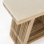 Detaljbild av pall i teak med tygsits i offwhite