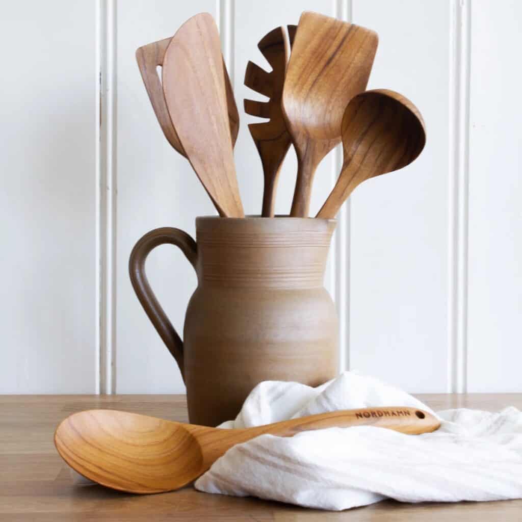 Soppslev i teak tillsammans med träredskap i keramikkanna på köksbänk
