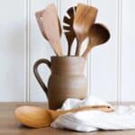 Soppslev i teak tillsammans med träredskap i keramikkanna på köksbänk