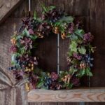 Konstgjord höstkrans med hortensia och bär som dekoration mot rustik trävägg