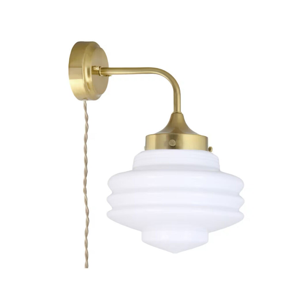 Vägglampa Valter i mässing med vit formad kupa av opalglas och beige textilsladd